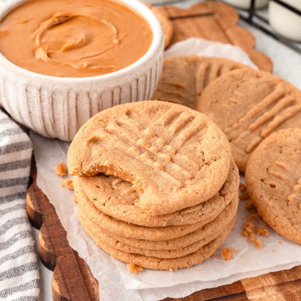 Butter cookies with peanut butter dip on a wooden tray.