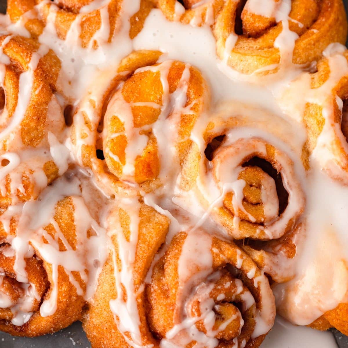 Cinnamon rolls topped with icing, fresh, warm, and delicious.